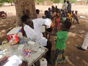 A health worker collects a blood sample from a child for a TAS in Burkina Faso